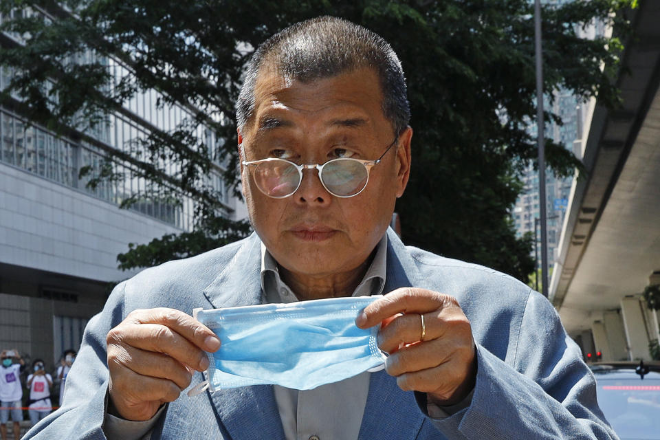 FILE - Hong Kong media tycoon Jimmy Lai, who founded local newspaper Apple Daily, prepare to put on a face mask before entering a court in Hong Kong on May 5, 2020. The trial of Hong Kong’s most famous activist publisher who was arrested under China’s crackdown on dissidents will start on Monday, Dec. 18, 2023 after being delayed for over a year. Jimmy Lai broke into the city’s once freewheeling media world about three decades ago, armed with the belief that delivering information is equal to protecting freedom. (AP Photo/Kin Cheung, File)