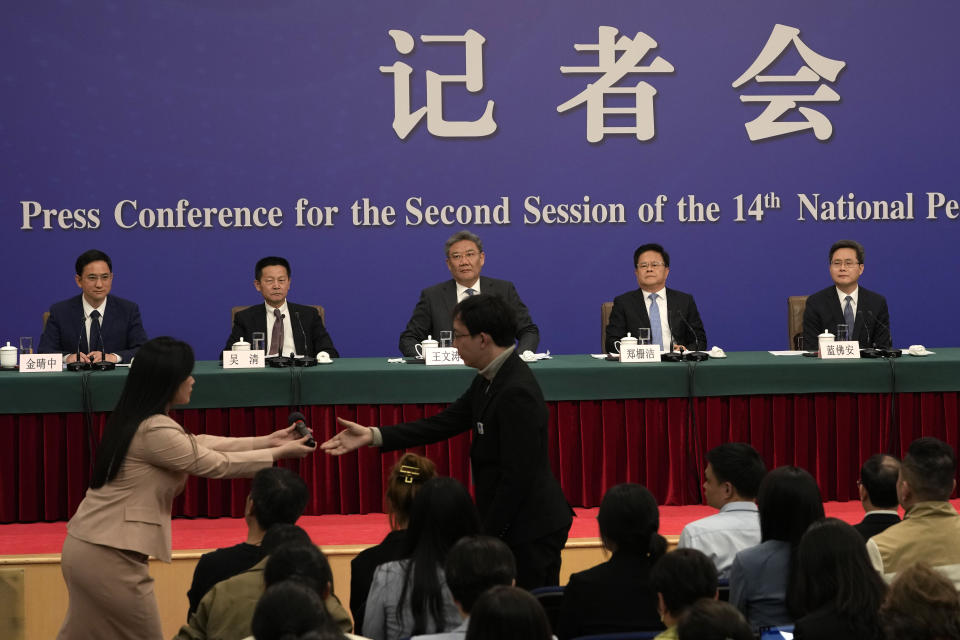 A journalist is handed a mic to ask question at a press conference for key Chinese finance and economy officials on the sideline of the National People's Congress in Beijing, Wednesday, March 6, 2024. Carefully screened questions are now the norm at press conferences, ensuring that fewer and fewer politically sensitive issues are raised. (AP Photo/Ng Han Guan)