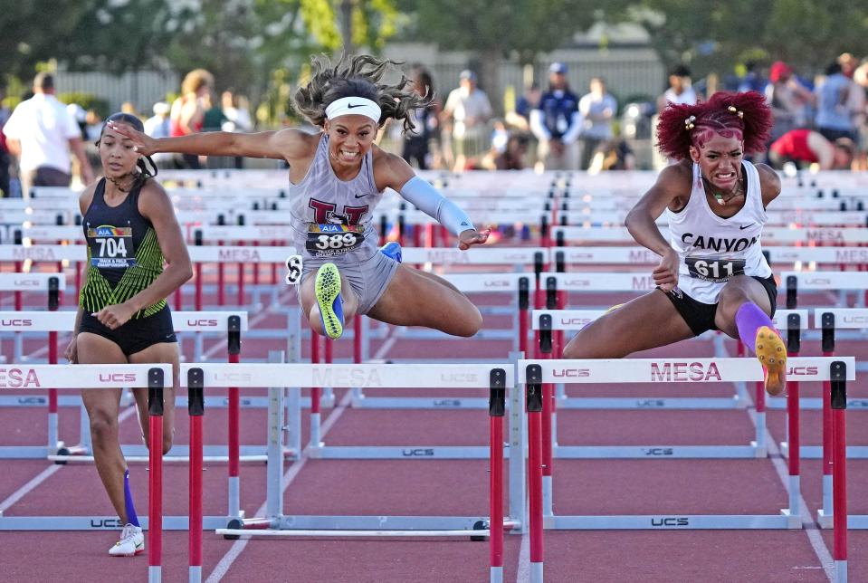 North Canyon's Rebekah-Jhade Garrett (right) wins the 100M Hurdles against Hamilton's Kori Martin (center) during the Open State Track and Field Championships at Mesa Community College on May 11, 2024.