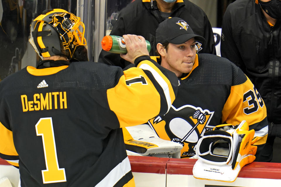 Pittsburgh Penguins goaltender Casey DeSmith (1) drinks during a timeout with goaltender Tristan Jarry (35) sitting on the bench during the third period of an NHL hockey game against the Washington Capitals in Pittsburgh, Sunday, Jan. 17, 2021. (AP Photo/Gene J. Puskar)