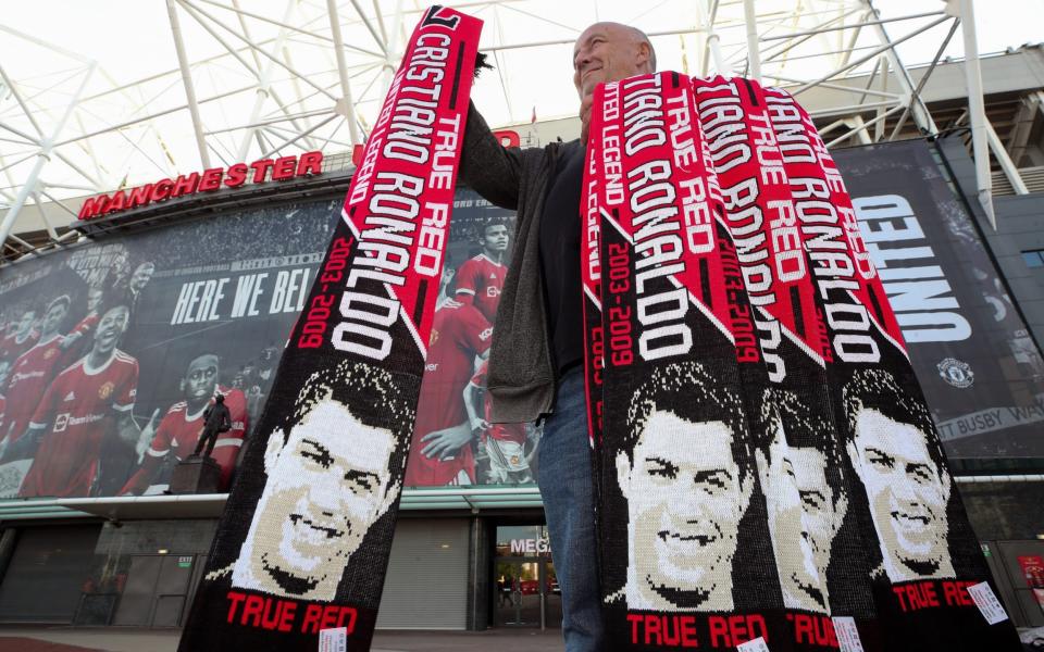 A vendor sells Cristiano Ronaldo scarves outside Old Trafford - PA