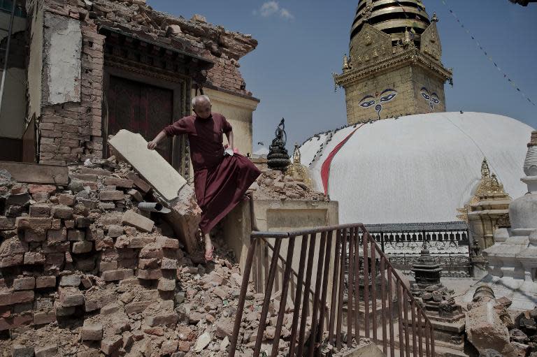 A Buddhist monk walks over the rubble of buildings near the Swayambhunath temple in Kathmandu, May 2, 2015