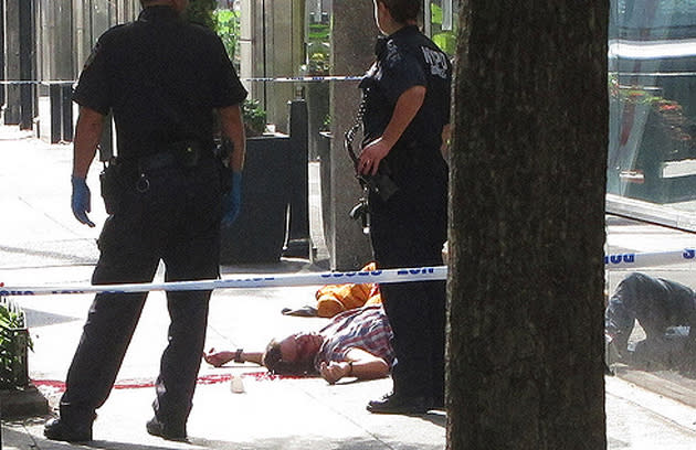 WARNING: GRAPHIC CONTENT. A man lies wounded on the ground after a tragic shooting at the Empire State Building in New York City. Twitter photo courtesy of Ben Doernberg (@UpdateBen)