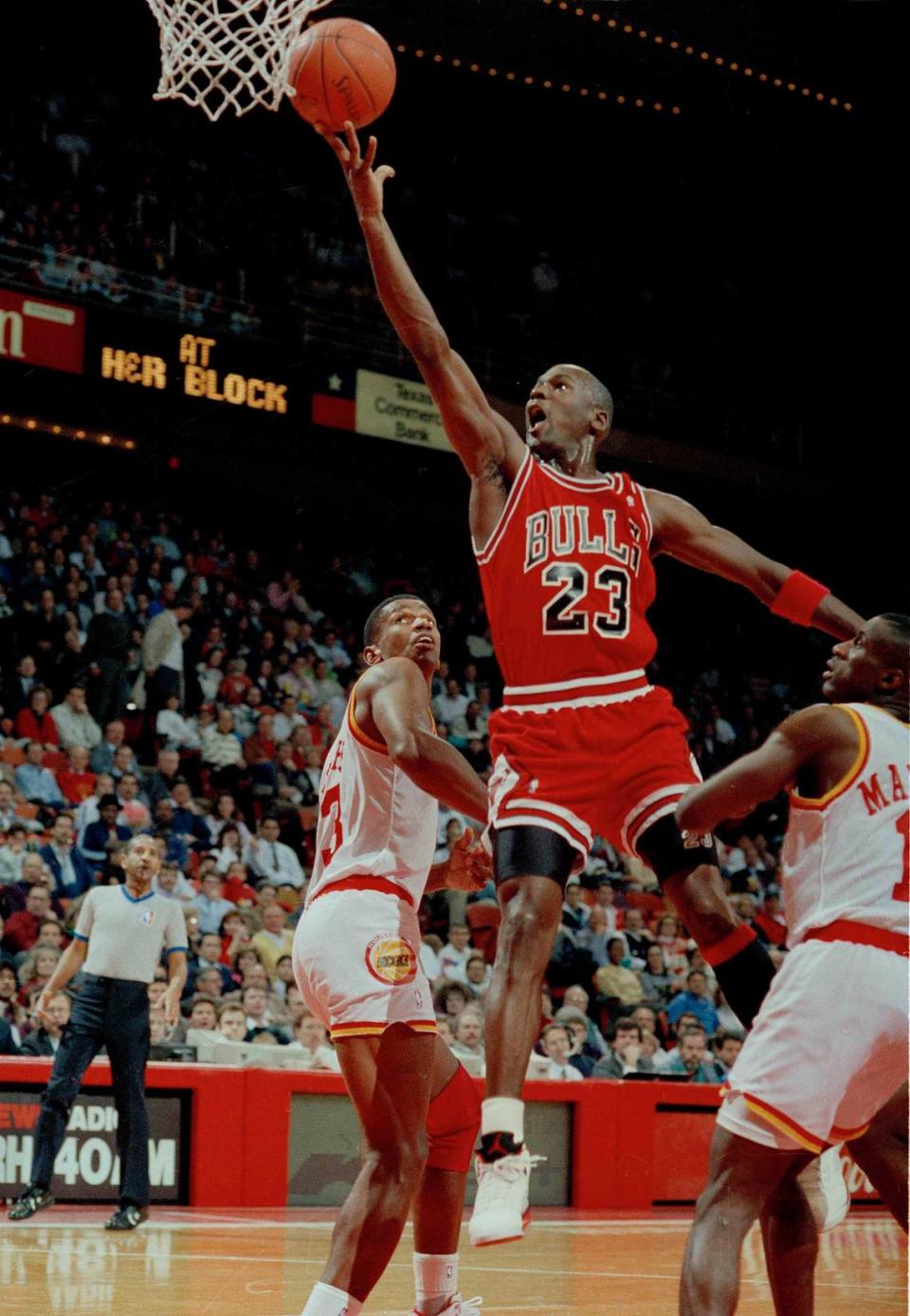 FILE - In this Jan. 3, 1991, file photo, Michael Jordan (23) of the Chicago Bulls drives the lane for a finger roll lay-up over Otis Thorpe, left, and Vernon Maxwell, right, of the Houston Rockets in the first half in Houston, Texas. Picking the car number for Michael Jordan’s new NASCAR team was a slam dunk: Bubba Wallace will drive the No. 23 car when the team makes its debut next season. (AP Photo/David Scarbrough, File)