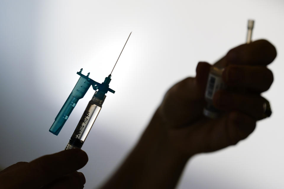 FILE - A syringe is prepared with the Pfizer COVID-19 vaccine at a clinic in the Norristown Public Health Center in Norristown, Pa., Tuesday, Dec. 7, 2021. The U.S. death toll from COVID-19 topped 800,000, a once-unimaginable figure seen as doubly tragic, given that more than 200,000 of those lives were lost after the vaccine became available practically for the asking. (AP Photo/Matt Rourke, File)