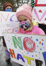 Anasofia Lopez, 5, of Grosse Pointe Park and her brother Joaquin Lopez, 8, left, stand with others prior to the start of the walking rally to protest against hate and racism in their neighborhoods Sunday, Feb. 21, 2021 in Grosse Pointe Park, Mich., following a white resident's display of a Ku Klux Klan flag in a side window facing their Black neighbor's home. JeDonna Dinges, 57, of Grosse Pointe Park, said the klan flag was hanging next door in a window directly across from her dining room. The incident occurred two weeks ago. (Clarence Tabb, Jr./Detroit News via AP)