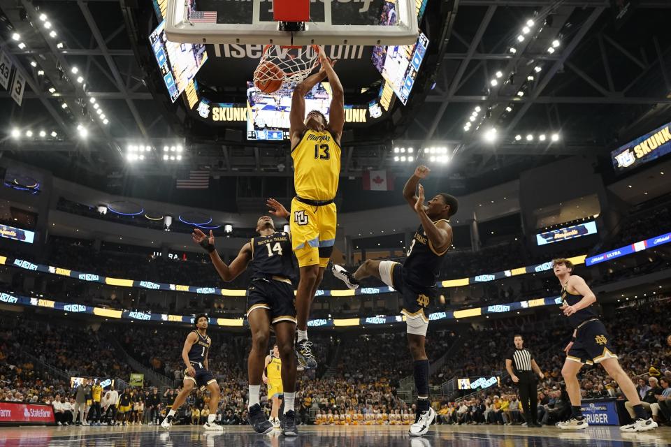 Marquette's Oso Ighodaro dunks past Notre Dame's Markus Burton and Kebba Nji during the first half of an NCAA college basketball game Saturday, Dec. 9, 2023, in Milwaukee. (AP Photo/Morry Gash)