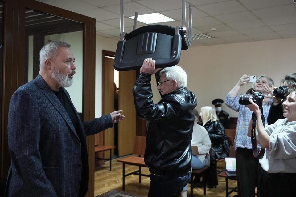Oleg Orlov, a member of the Board of the International Historical Educational Charitable and Human Rights Society 'Memorial' (International Memorial), centre, carries a chair, as Nobel Peace Prize awarded journalist Dmitry Muratov, editor-in-chief of the influential Russian newspaper Novaya Gazeta, left, speaks to journalists at a courtroom prior to a session in Moscow, Russia, Wednesday, Oct. 11, 2023. Orlov, the co-chair of the Nobel Peace Prize-winning human rights group Memorial, is on trial on charges of 