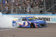 Kyle Larson celebrates after winning a NASCAR Cup Series auto race and championship on Sunday, Nov. 7, 2021, in Avondale, Ariz. (AP Photo/Rick Scuteri)