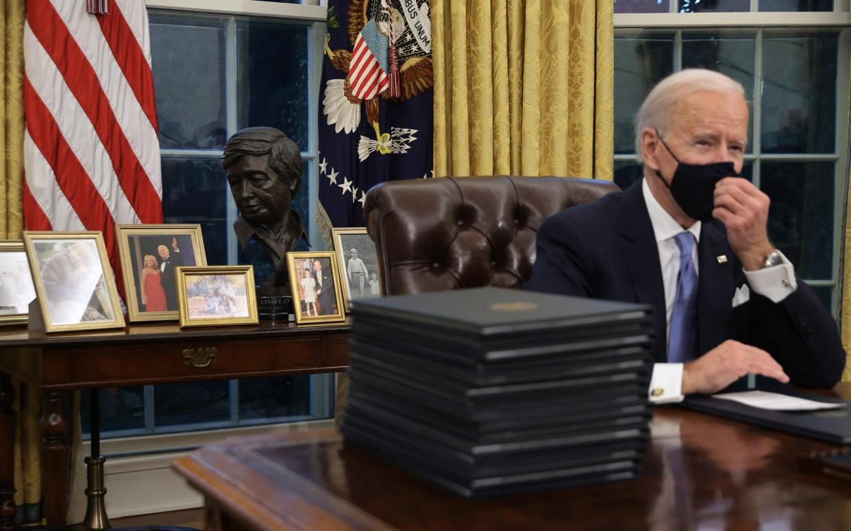 Joe Biden at the Resolute Desk in the Oval Office just hours after his inauguration - Getty