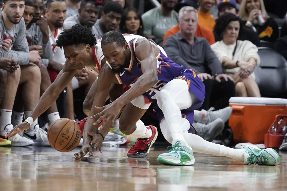 Houston Rockets forward Amen Thompson, left, battles Phoenix Suns forward Kevin Durant (35) for the ball during the first half of an NBA basketball game in Phoenix, Saturday, March. 2, 2024. (AP Photo/Darryl Webb)