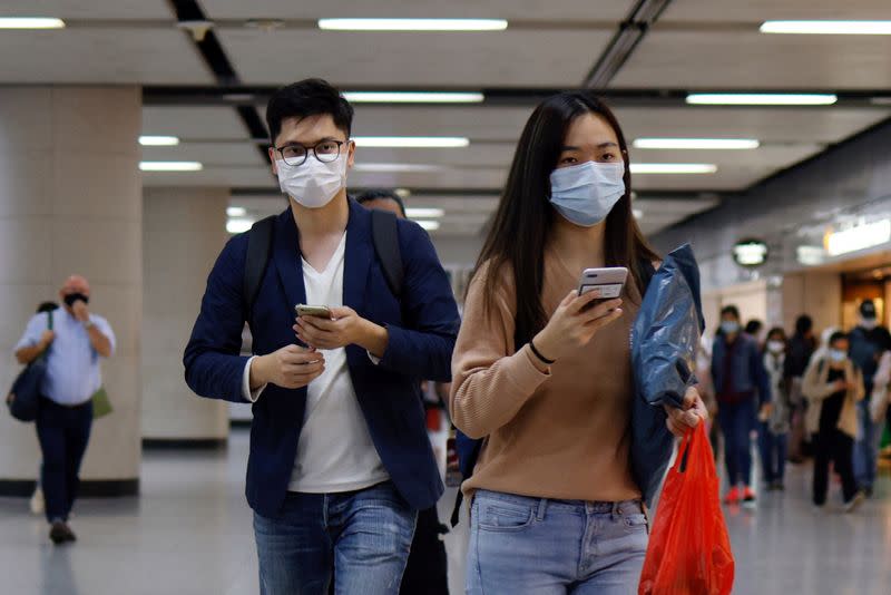 People wear masks following the coronavirus disease (COVID-19) outbreak, at the financial Central district in Hong Kong
