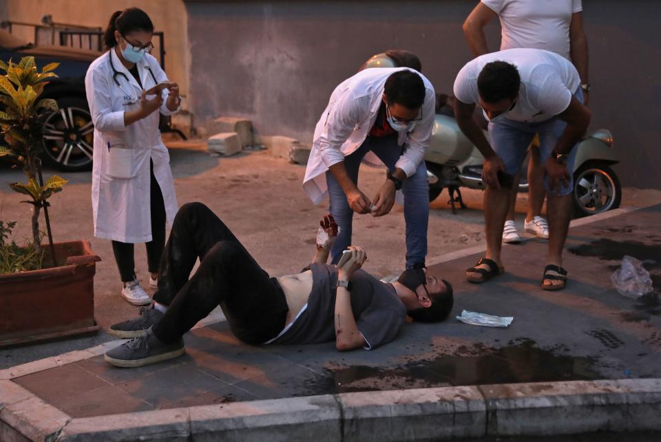 A wounded man waits to received help outside a hospital following an explosion in the Lebanese capital Beirut on August 4, 2020. - Two huge explosion rocked the Lebanese capital Beirut, wounding dozens of people, shaking buildings and sending huge plumes of smoke billowing into the sky. Lebanese media carried images of people trapped under rubble, some bloodied, after the massive explosions, the cause of which was not immediately known. (Photo by IBRAHIM AMRO / AFP) (Photo by IBRAHIM AMRO/AFP via Getty Images)