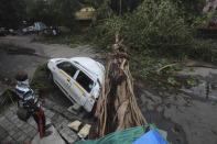 A car stands damaged with a fallen tree after heavy rainfall in Mumbai India, Tuesday, May 18, 2021. The Maharashtra state capital was largely spared from any major damage as Cyclone Tauktae, the most powerful storm to hit the region in more than two decades, came ashore in neighboring Gujarat state late Monday. (AP Photo/Rafiq Maqbool)