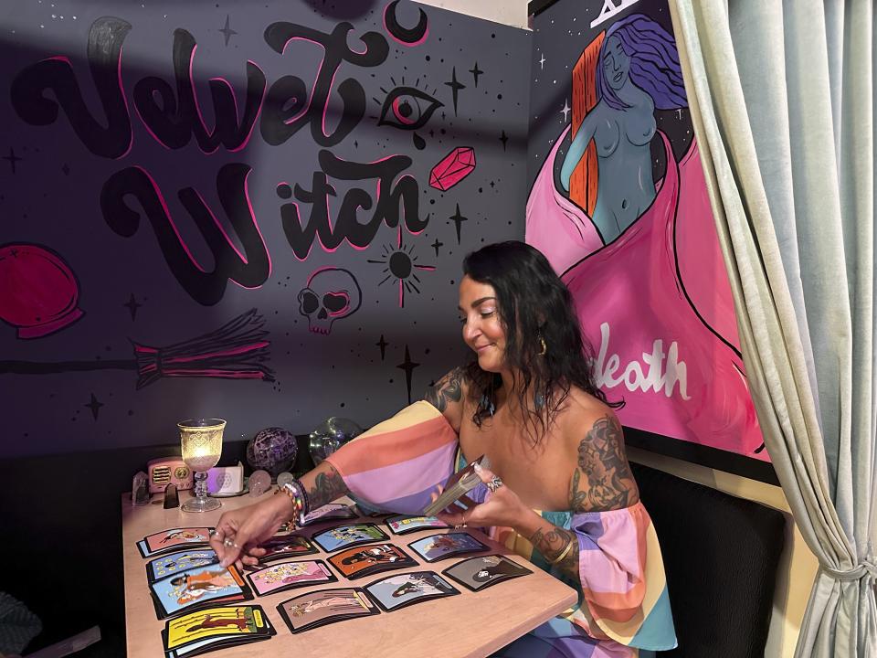 Ashley Branton lays out tarot cards in the back of her shop, Velvet Witch, in Norfolk, Va., Thursday, June 13, 2024. The city of Norfolk recently repealed its 45-year-old ban on “the practice of palmistry, palm reading, phrenology or clairvoyance, for monetary or other compensation.” The 1979 ordinance was not being enforced, however, and the psychic services industry is growing. (AP Photo/Ben Finley)