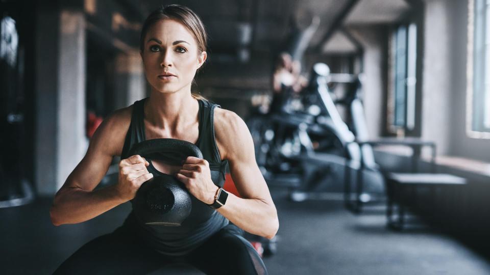 Cropped shot of an attractive young woman working out with a kettle bell in the gym.