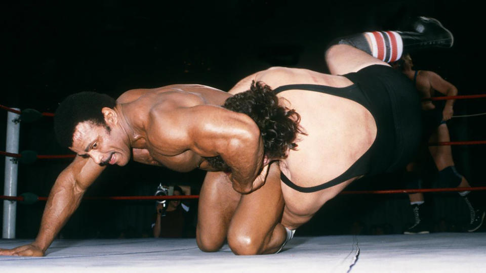 In this undated photo provided by WWE, Inc., Rocky "Soul Man" Johnson, left, wrestles an opponent in the ring. Johnson, a WWE Hall of Fame wrestler who became better known as the father of actor Dwayne “The Rock” Johnson, died Wednesday, Jan. 15, 2020. He was 75. (WWE, Inc. via AP)