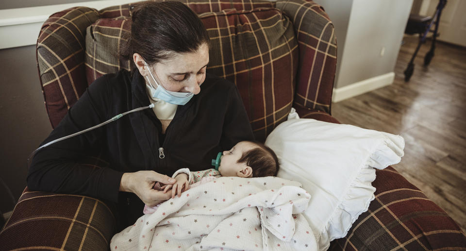 In this Jan. 27, 2021 photo provided by Taryn Marie Photography, Kelsey Townsend meets her daughter Lucy for the first time face to face in Poynette, Wis. Kelsey Townsend gave birth to Lucy via C-section on Nov. 4 while in a medically induced coma due to COVID-19. She spent 75 days on lung and life support. She was discharged from University Hospital in Madison on Jan. 27. (Taryn Ziegler/Taryn Marie Photography via AP)