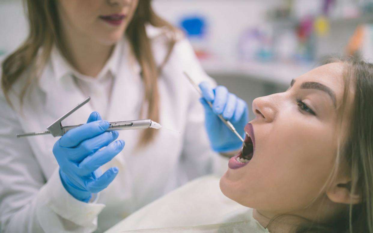 A dentist examining a patient - Dusanmanic/Getty Images