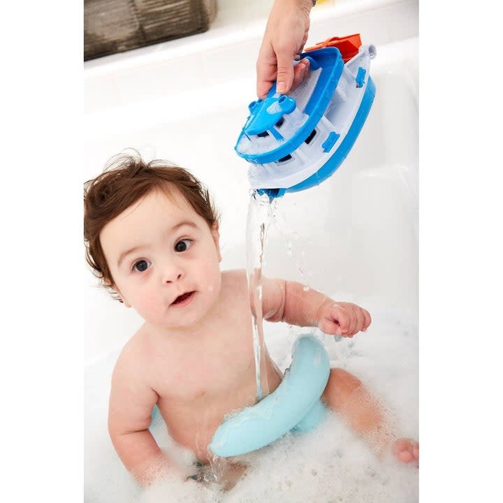 Baby in a tub with a blue paddle boat bath toy