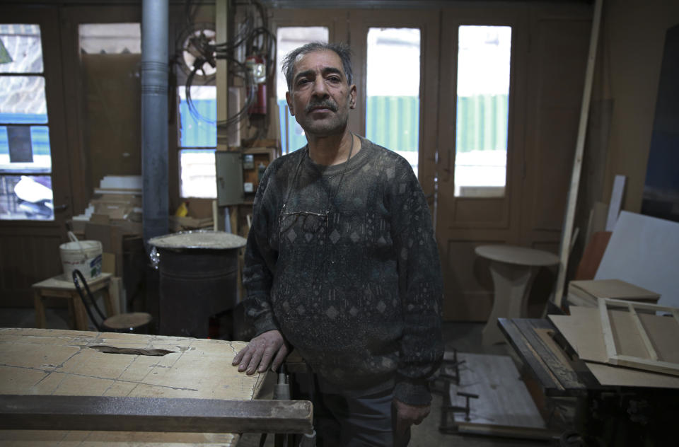 In this Tuesday, Jan. 22, 2019 photo, carpenter Mohammad Reza Tajik is interviewed by The Associated Press about Iran's 1979 Islamic Revolution at his workshop, in northern Tehran, Iran. Forty years after he defected from the shah’s Imperial Guard to join the Islamic Revolution, Tajik, like many Iranians from that time, looks back wistfully at the youthful excitement they felt and the losses they suffered since then. (AP Photo/Vahid Salemi)