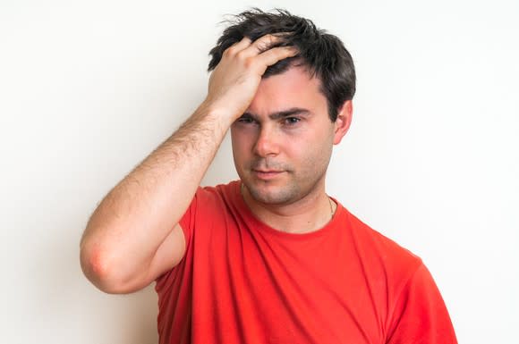 Man smacking his own head after making a mistake