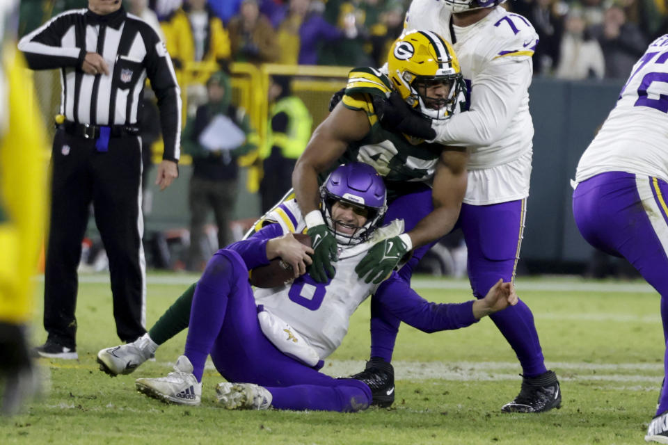 Minnesota Vikings quarterback Kirk Cousins (8) is sacked by Green Bay Packers linebacker Justin Hollins (47) during the first half of an NFL football game, Sunday, Jan. 1, 2023, in Green Bay, Wis. (AP Photo/Matt Ludtke)