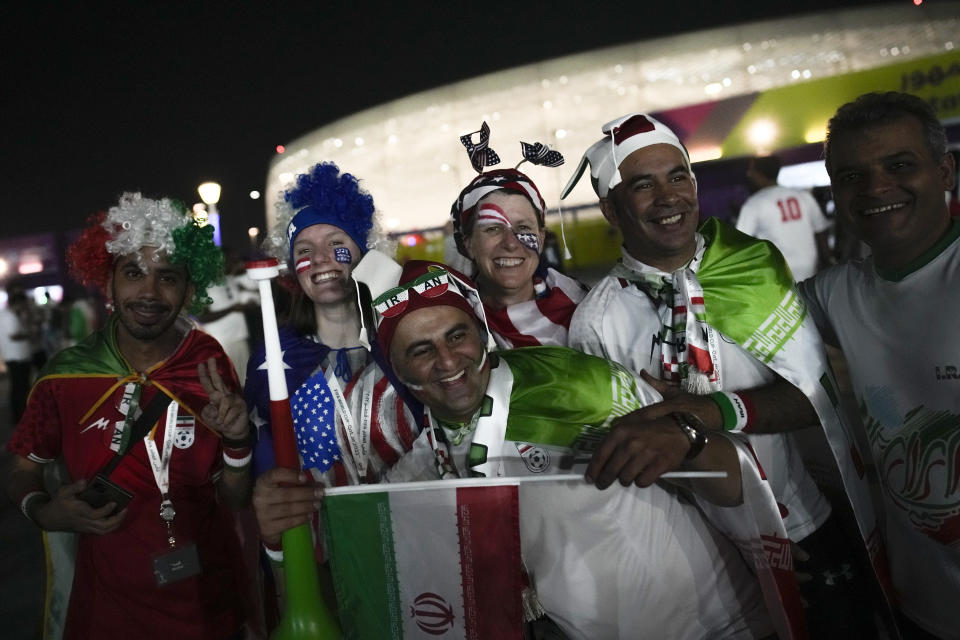 Aficionados iraníes y estadounidenses animan antes del partido del Grupo B que enfrentará a los dos equipos en el estadio Al Thumama, en Doha, Qatar, el 29 de noviembre de 2022. (AP Foto/Christophe Ena)