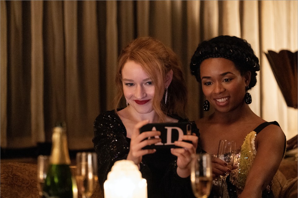 A white woman taking a selfie at a party with a Black woman