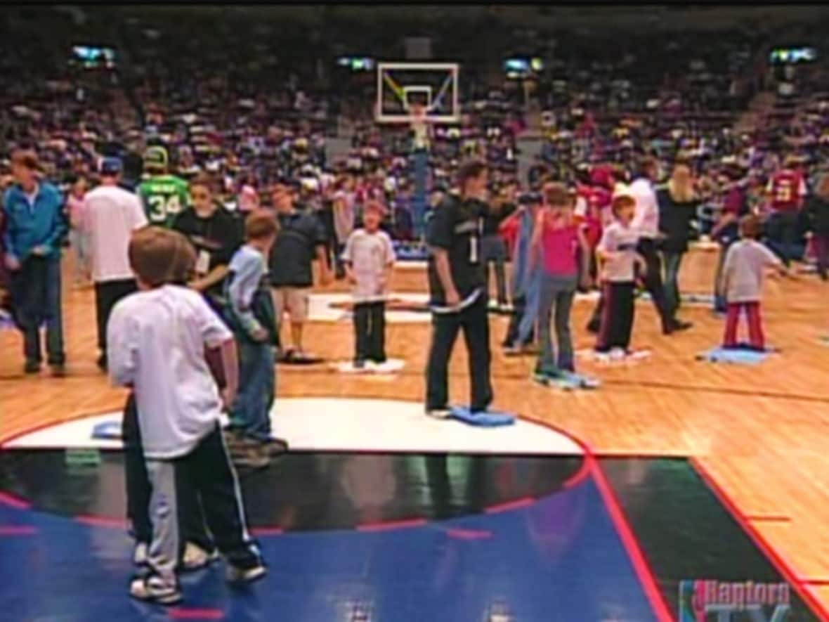 Fans took to the floor to help mop up condensation ahead of what was supposed to be an exhibition game between the Toronto Raptors and Cleveland Cavaliers in St. John's in October 2003.  (CBC Archives - image credit)