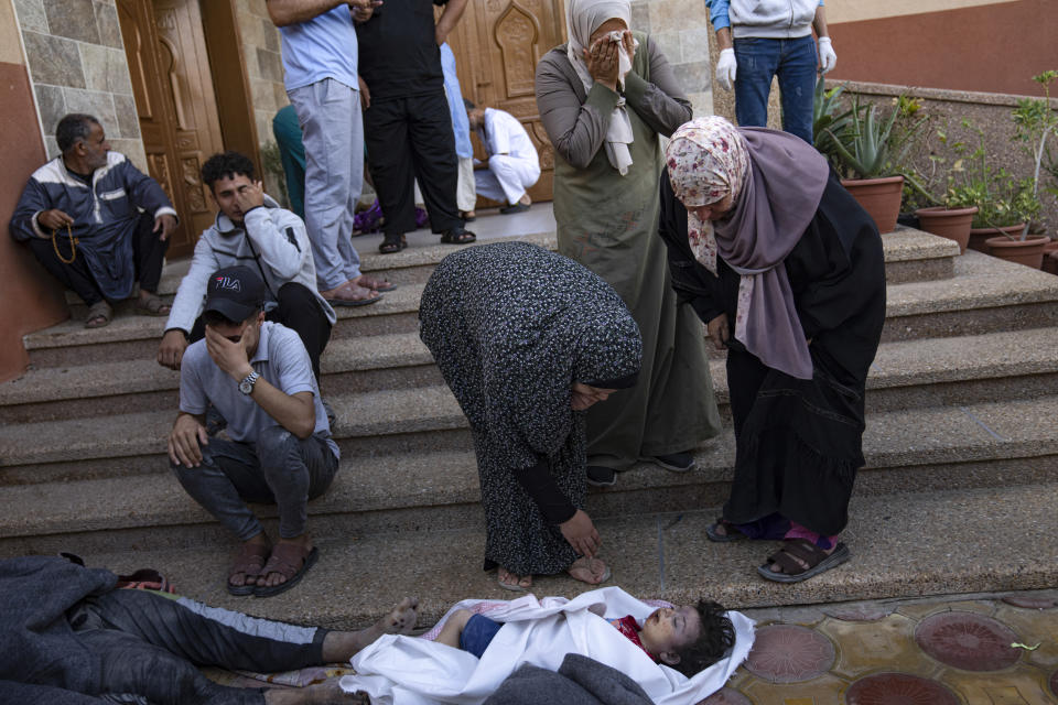 Palestinians mourn relatives killed in the Israeli bombardment of the Gaza Strip in a morgue in Khan Younis, Tuesday, Oct. 17, 2023. (AP Photo/Fatima Shbair)