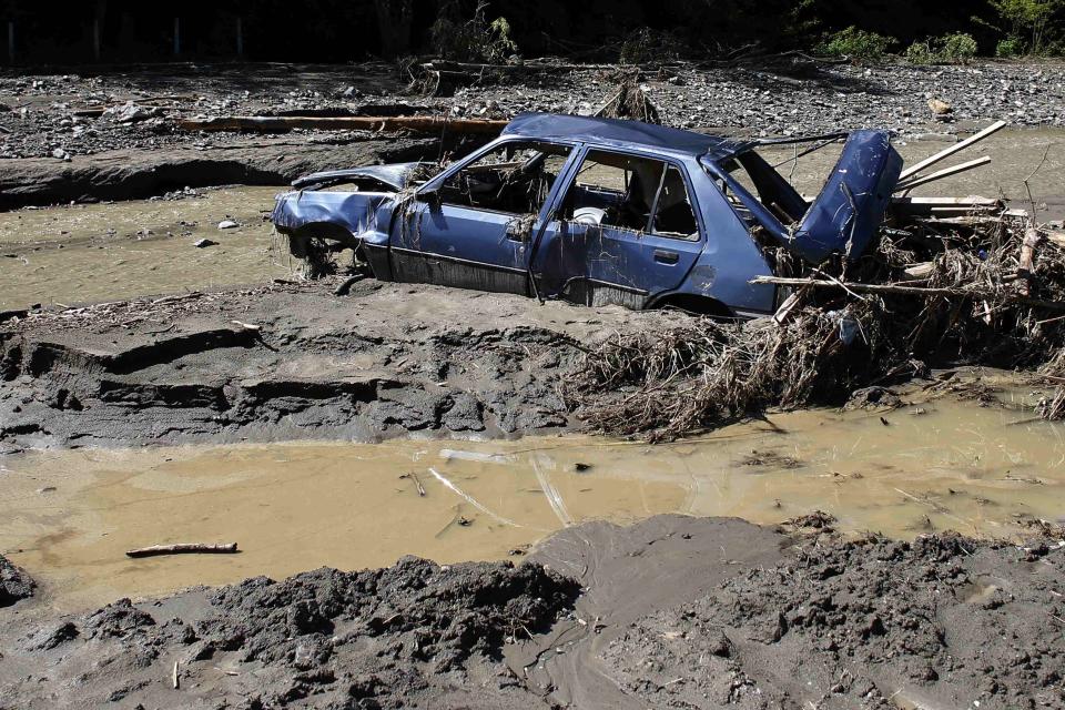 A damaged car lies in mud caused by floods in the village of Krupanj, west from Belgrade