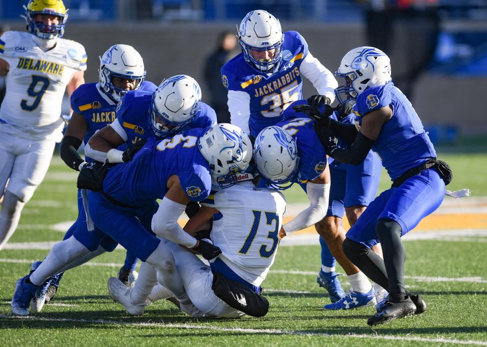 South Dakota State players swarm Delaware’s Brett Buckman to tackle him in an FCS playoff game on December 3, 2022, at Dana J. Dykhouse Stadium in Brookings.