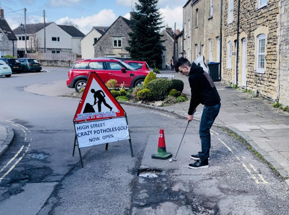 Ben Thornbury demonstrating 'crazy pothole golf' in Malmesbury. (SWNS)