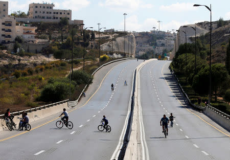 Children ride their bicycles in an empty street in Jerusalem during the Jewish holiday of Yom Kippur, September 19, 2018. Most Israeli Jews refrain from driving during the 25-hour period. REUTERS/Ammar Awad