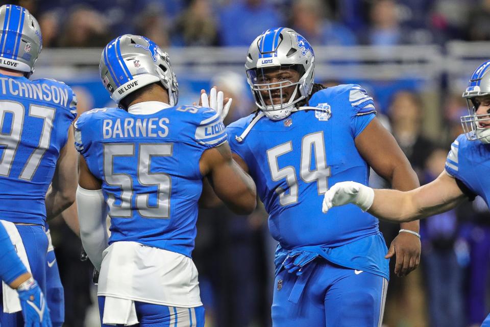 Lions defensive tackle Alim McNeill, right, high-fives linebacker Derrick Barnes during warmups before the NFC wild-card game at Ford Field on Sunday, Jan, 14, 2024.