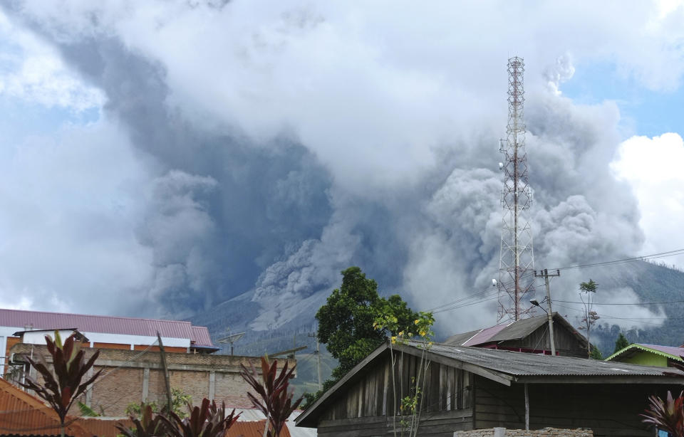 Mount Sinabung releases volcanic materials during an eruption as seen from a school yard in Karo, North Sumatra, Indonesia, Wednesday, July 28, 2021. The rumbling volcano on Indonesia’s Sumatra island on Wednesday shot billowing columns of ash and hot clouds down its slopes. (AP Photo/Sastrawan Ginting)