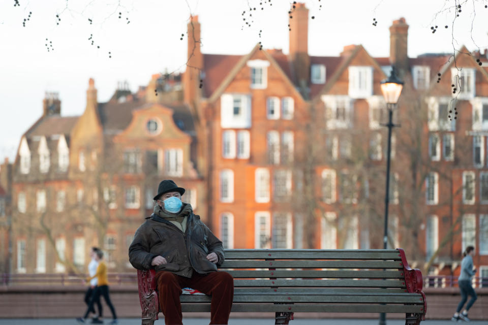 A man wearing a face covering sits on a bench in Battersea Park in London during the third covid lockdown. Photo date: Friday, January 29, 2021. Photo credit should read: Richard Gray/EMPICS