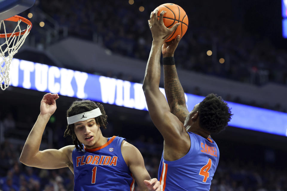 Florida's Tyrese Samuel (4) pulls down a rebound next to teammate Walter Clayton Jr. (1) during the first half of an NCAA college basketball game against Kentucky, Wednesday, Jan. 31, 2024, in Lexington, Ky. (AP Photo/James Crisp)