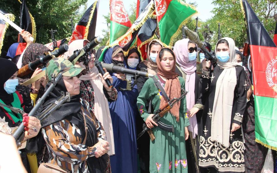 Women took up arms to march through the streets of several Afghan towns in a show of defiance as the Taliban make sweeping gains nationwide 