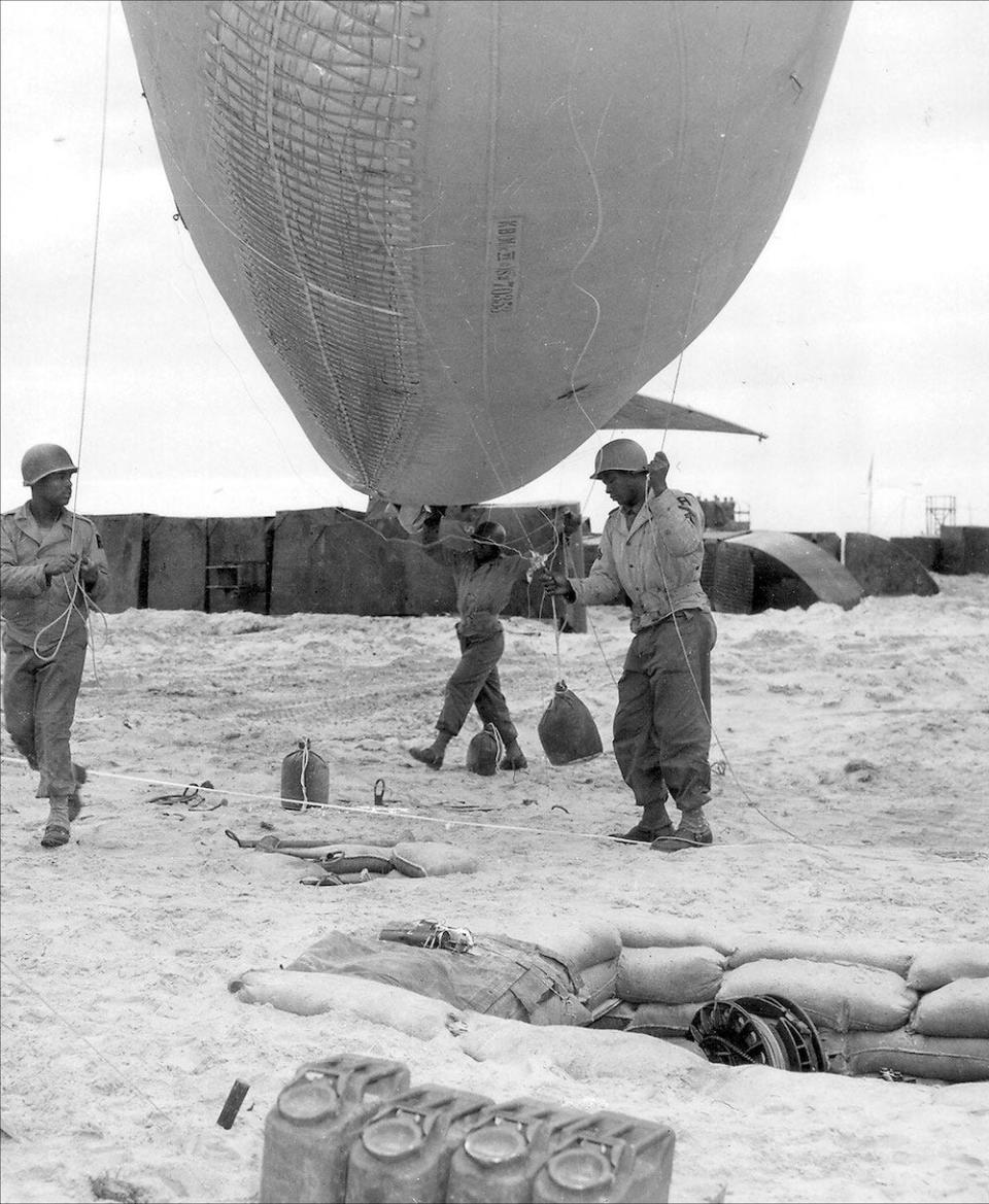 Soldiers of the 320th Anti Aircraft Barrage Balloon Battalion, 1st US Army prepare to deploy a barrage balloon on Utah Beach during the Normandy invasion