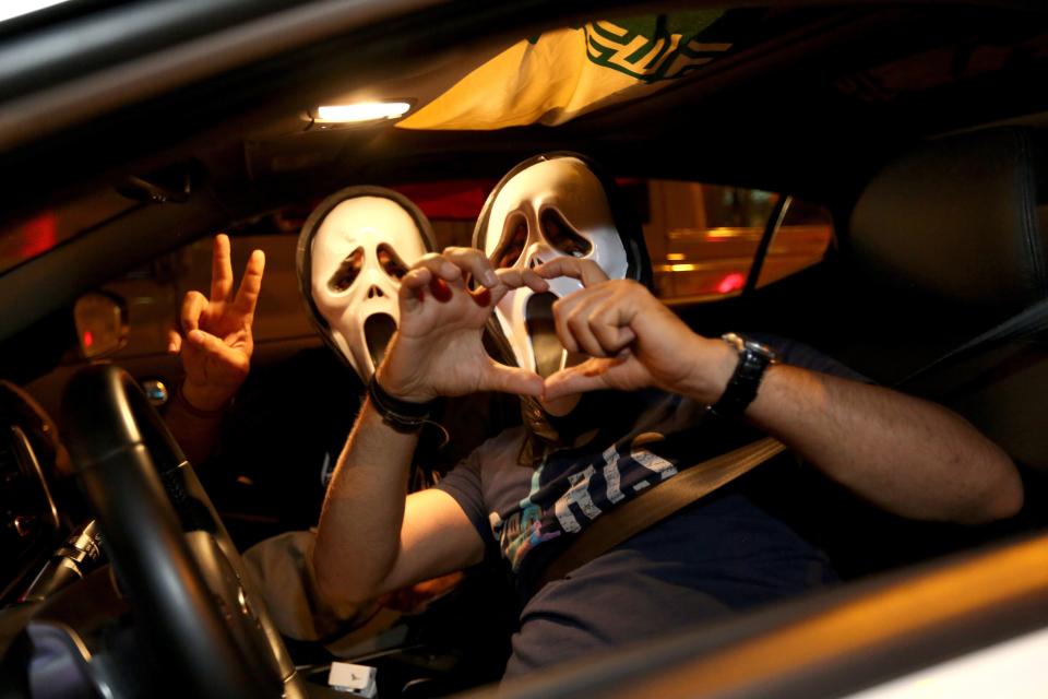 Iranian wearing the mask of 'The Scream' move flash the v sign for victory and a heart during celebration in northern Tehran on July 14, 2015, after Iran's nuclear negotiating team struck a deal with world powers in Vienna. 