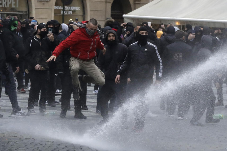 Water canon is used against demonstrators as they gather to protest against the COVID-19 restrictive measures at Old Town Square in Prague, Czech Republic, Sunday, Oct. 18, 2020. The Czech Republic has imposed a new series of restrictive measures in response to a record surge in coronavirus infections. Among the measures all sports indoor activities are banned and only up to 20 people are allowed to participate in outdoor sport activities also all bars, restaurants and clubs are closed while drinking of alcohol is banned at public places. (AP Photo/Petr David Josek)