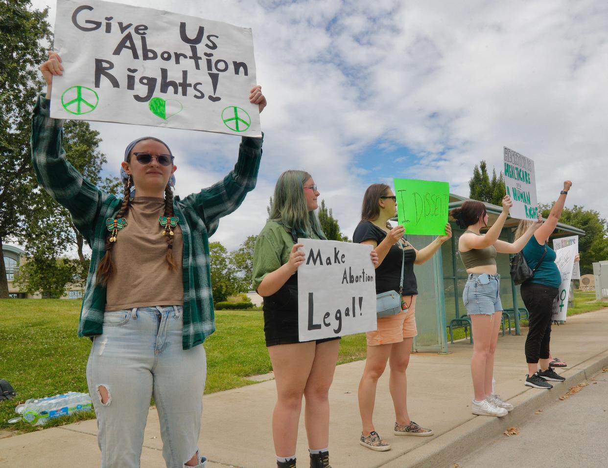 A women's rights protest organized by 14-year-old Emily Finck of Redding, second from left, was greeted with honks of support by drivers along Cypress Avenue on Monday, July 4, 2022.