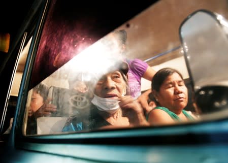 Women are seen in a bus before evacuation in San Lorenzo Community, an area where wildfires have destroyed hectares of forest, near Robore