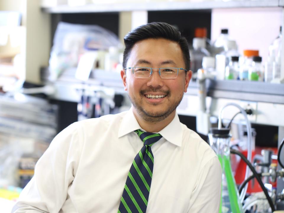 Dr. Alfred Kim, an Asian-American man, poses in a laboratory.