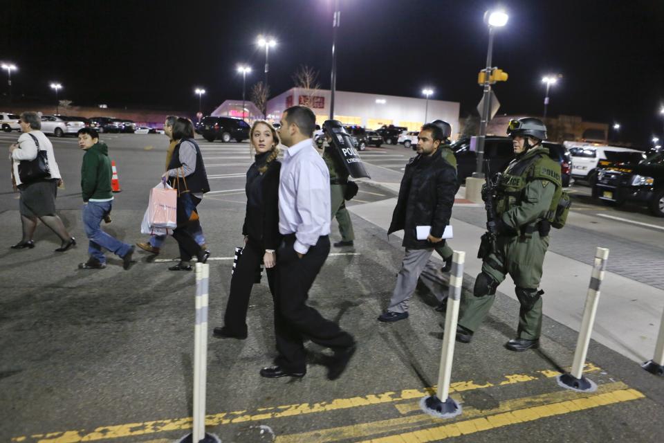 Policemen escort workers and shoppers from the Garden State Plaza mall after a lock down during police response to reports that a gunman had fired shots, in Paramus