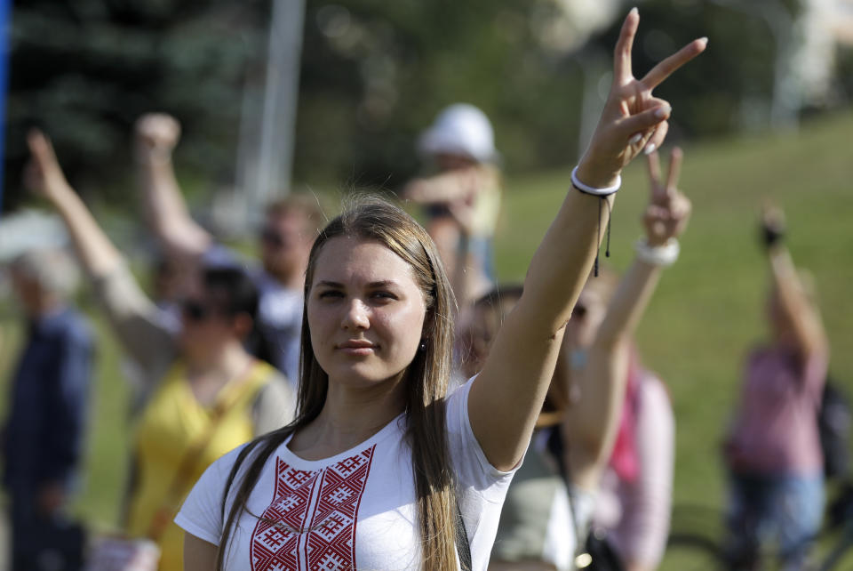 A woman gestures as she and other people gather to pay the last respect a protester who died amid the clashes with police, in Minsk, Belarus, Tuesday, Aug. 11, 2020. Thousands of opposition supporters who also protested the results met with a tough police crackdown in Minsk and several other Belarusian cities for two straight nights. Belarus' health officials said over 200 people have been hospitalized with injuries following the protests, and some underwent surgery. (AP Photo/Sergei Grits)