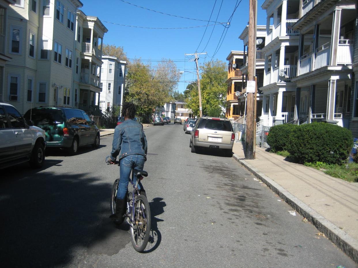 This narrow street, lined with parked cars but devoid of people, is both unwelcoming and unsafe for cyclists. Anne Lusk, <a href="http://creativecommons.org/licenses/by-nd/4.0/" rel="nofollow noopener" target="_blank" data-ylk="slk:CC BY-ND;elm:context_link;itc:0;sec:content-canvas" class="link ">CC BY-ND</a>