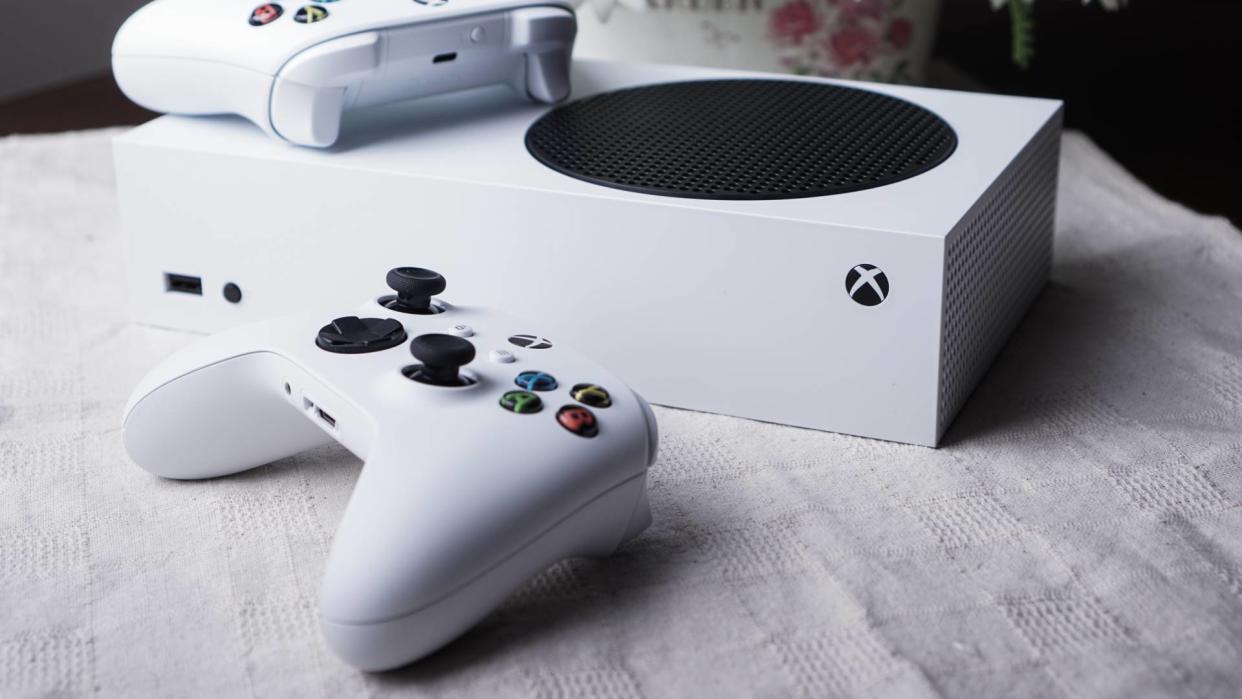  Xbox Series S on a white table top with two white controllers. 